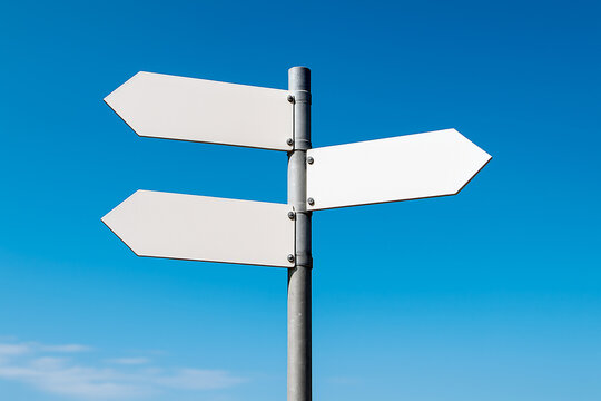 A blank white directional signpost with three arrow-shaped signs, angled in different directions against a clear blue sky. For illustrating choice, direction, decision-making, or travel concepts