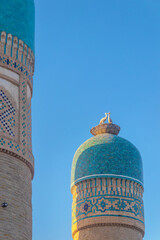 Bukhara, Uzbekistan, a detail of minarets with a sculpture depicting a stork's nest (a national...