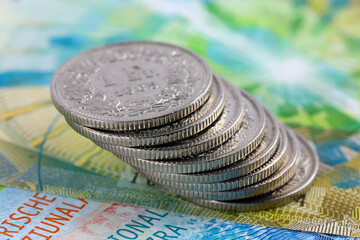 A slanted stack of coins on banknotes, CHF currency