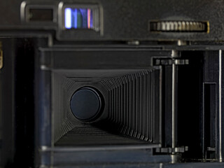 The back of an old compact camera with the lid of the film compartment open