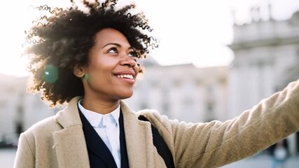 Smiling woman with curly hair reaching out, urban backdrop suggests exploration or travel, joyful expression adds warmth and positivity
