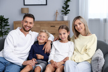 Happy family sitting on sofa at home