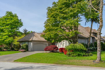 Two story stucco luxury house with nice spring blossom landscape in Vancouver, Canada, North...