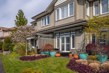 Two story stucco luxury house with nice spring blossom landscape in Vancouver, Canada, North...