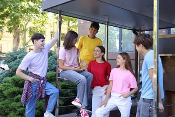 Group of happy teenage friends spending time together outdoors