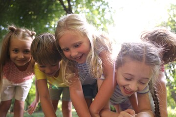 Cute little kids having fun together in park, low angle view