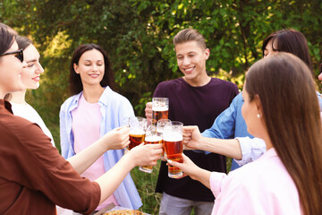 Group of happy friends clinking glasses of beer outdoors