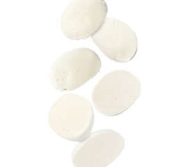 Mozzarella cheese pieces falling against white background