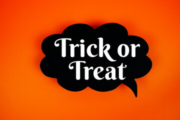 Trick or Treat text on speech bubble top view on orange background