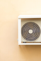air conditioner in an anti-vandal grid is installed on wall of house. ventilation and cooling of...