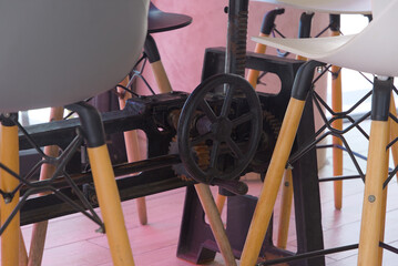 A close-up shot shows the industrial-style base of a table with a hand crank and gear mechanism,...