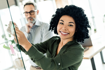 Confident colleagues brainstorming in a vibrant workspace showcasing teamwork and creativity