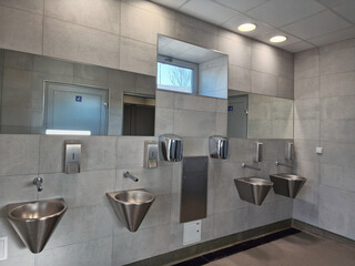 public toilet with stainless steel sinks in car park highway