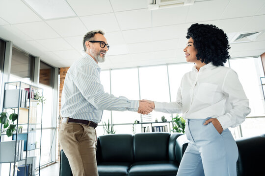 Professional colleagues greeting with a handshake in a stylish modern office setting showcasing collaboration and teamwork