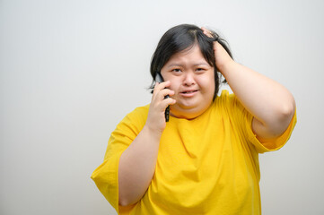 Portrait of a woman with Down syndrome, talking on mobile phone with a worried and stressed...