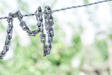Creative chain made from aluminum can tabs on green nature background, a conceptual artwork...