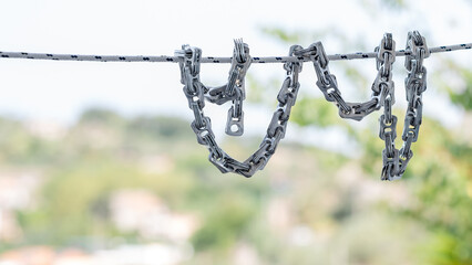 Creative chain made from aluminum can tabs on green nature background, a conceptual artwork...