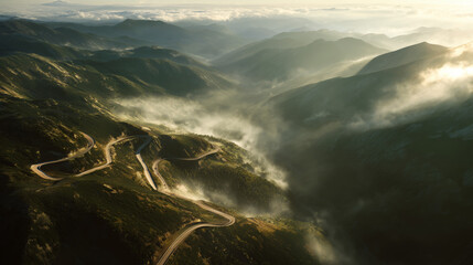 Winding road through foggy mountain landscape at sunrise