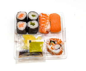 Take away sushi assortment with condiments in plastic box
