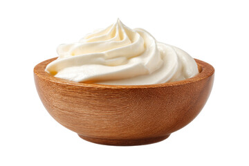 A bowl of whipped cream sits on a white background. The bowl is wooden and the cream is white and fluffy