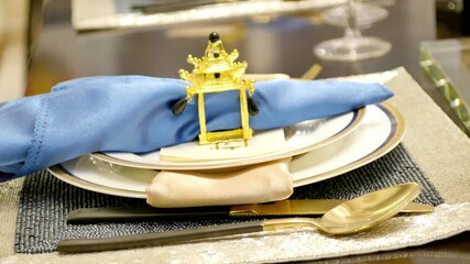 Elegant table setting with a golden napkin ring and blue linen napkin