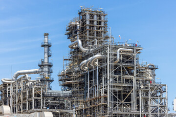 Fototapeta premium Oil and Gas refinery petrochemical plant industrial on blue sky background, Oil and Gas refinery petrochemical plant pipeline steel, Oil and Gas refinery factory maintenance, Global energy refinery.