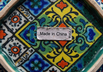 Obraz premium a colorful ceramic plate featuring intricate patterns and a label indicating it is made in china