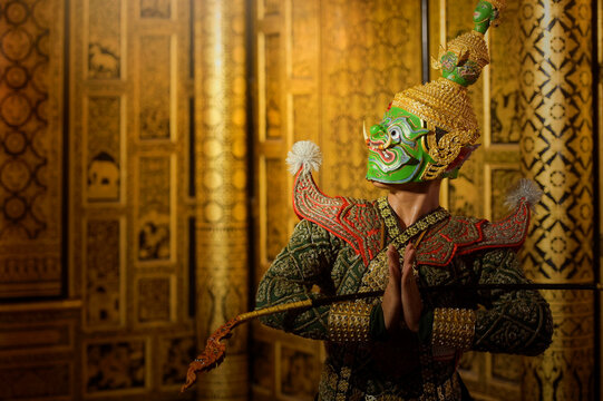 Traditional khon dancer in a mask and stage costume performing inside a temple, Thailand