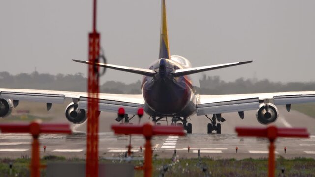 A huge wide-body four-engine airliner on the runway, rear view. Concept aviation, flight, tourism, cargo transportation, travel