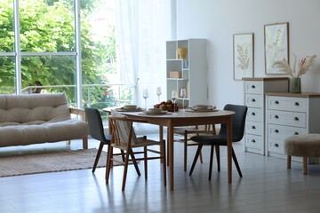 Beautiful table setting, chairs and decor in dining room. Interior design