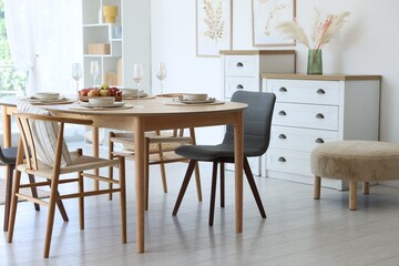 Beautiful table setting, chairs and decor in dining room. Interior design