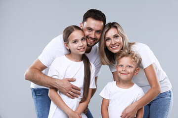 Fototapeta premium Family portrait of happy parents and their children on grey background