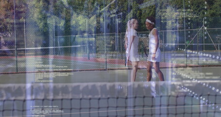 Facing two female players holding rackets exchanging gazes on outdoor tennis court, code overlay