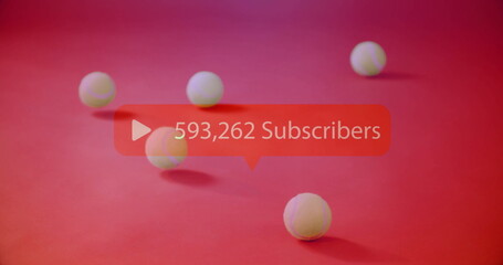 Red subscriber bubble floating on studio backdrop with white play-button icon and six tennis balls