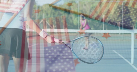 Swinging woman wearing striped top skirt holding racket on hardcourt with net under sunny sky