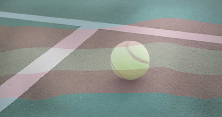 Resting bright yellow tennis ball lying near white boundary line intersection on green tennis court