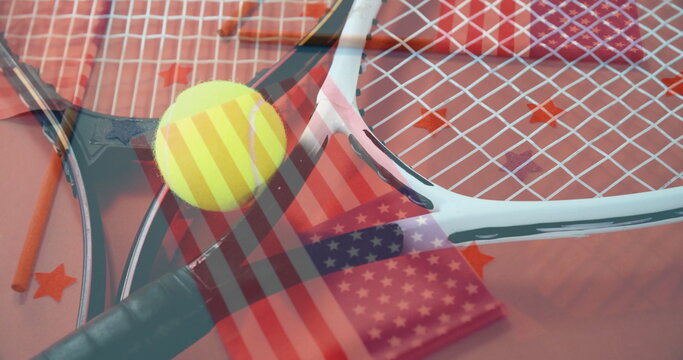 Naklejki Arranging crossed tennis rackets on studio table with tennis ball, star confetti and flag overlay