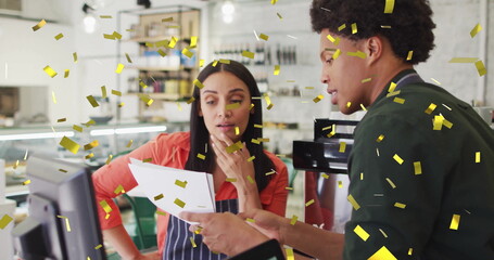 Reviewing printed report cafe staff wearing aprons at counter with espresso maker and gold confetti