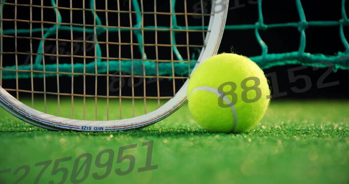 Fototapeta Resting tennis ball sitting on green court near racket frame and strings, with net, copy space