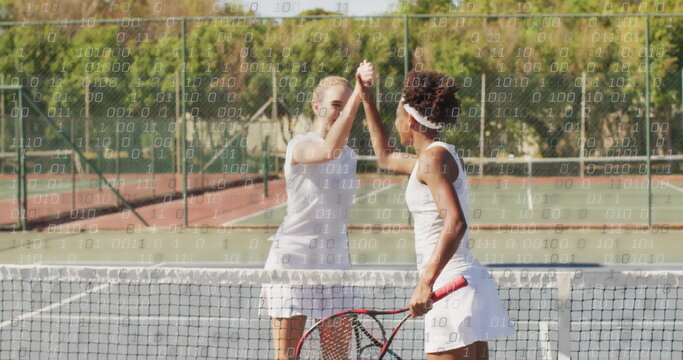 High-fiving two female players wearing white tennis outfits on outdoor court, with rackets and net - Powered by Adobe
