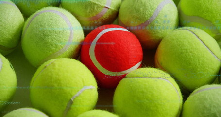 Overlapping yellow-green tennis balls forming contrast on flat surface, with single red tennis ball