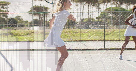 Swinging woman in white dress hitting forehand on tennis court with tennis racket, fence, sneakers