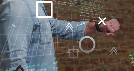 Man in denim shirt manipulating financial overlay in office, with smartwatch and stock symbols