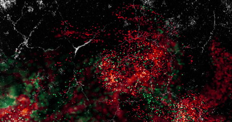 Forming clusters of luminous red and green particles on black field, with white filament streaks