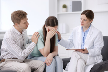 Obraz premium In vitro fertilization (IVF). Upset couple having appointment with doctor in reproductive clinic