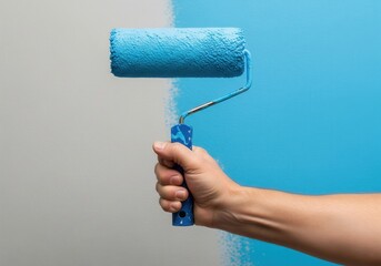 A hand holds a paint roller applying vibrant blue paint onto a wall, creating a clear division between painted and unpainted surfaces.