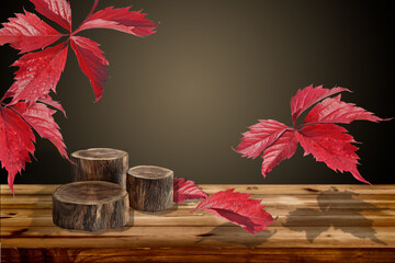 red autumn leaves of wild grapes fall on a wooden table with three round logs