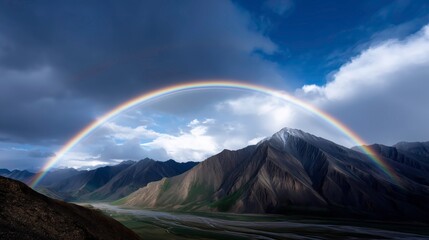 Perfect Rainbow Curving Elegantly above Rugged Mountain Range in Clear Light