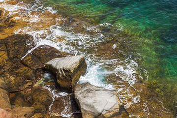 Atlantic Ocean waves washing over rocky shore against background of green and turquoise water. Spain. Grand Canaia.