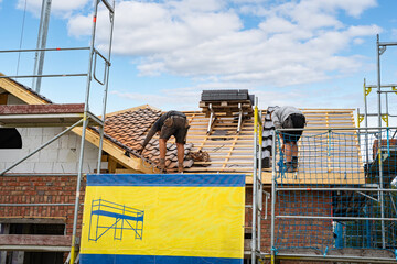 Wohnhausbau - Dachdeckerarbeiten beim Eindecken eines neuen Einfamilienhauses.